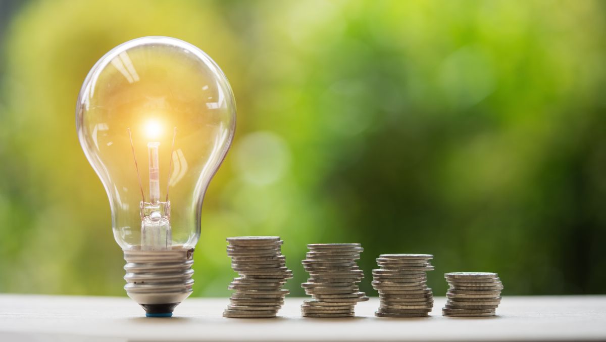 Light bulb and stacks of coins